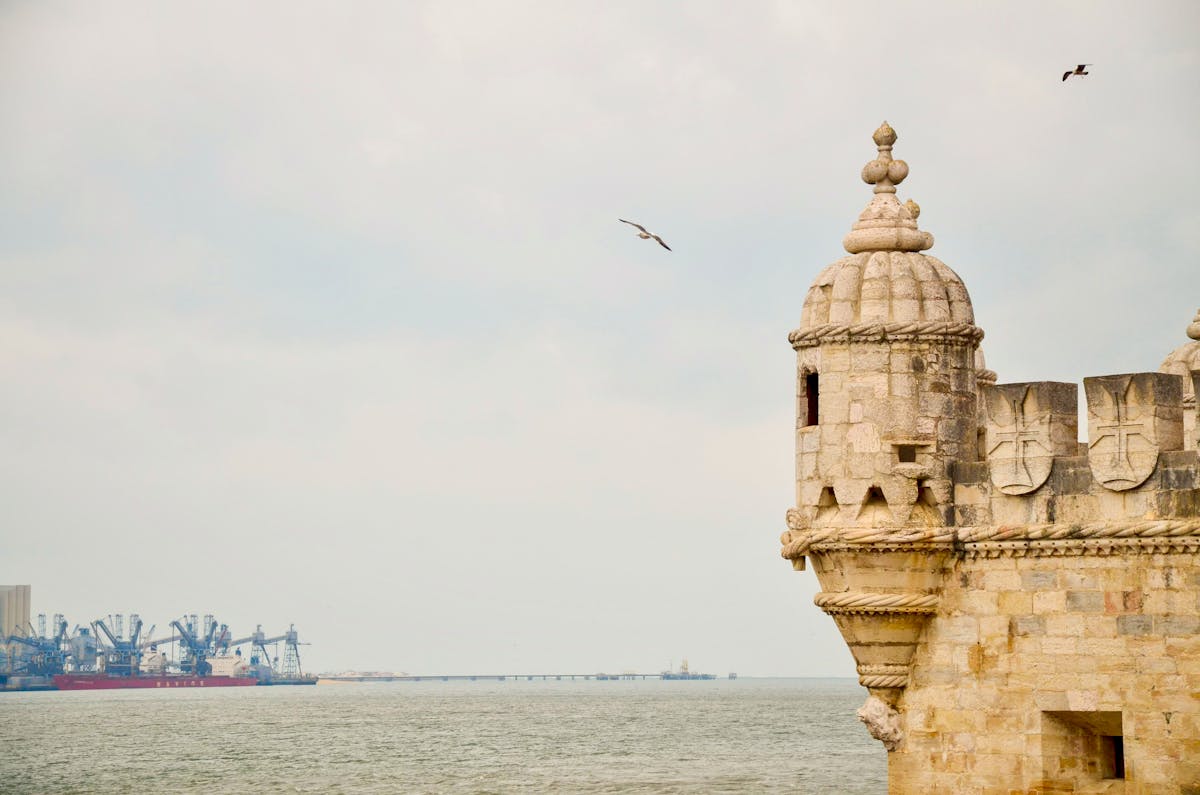 Belem Tower on the waterfront in Lisbon with birds in flight