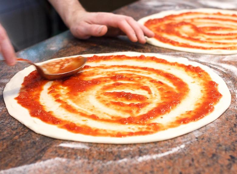 Adding sauce to the pizza 