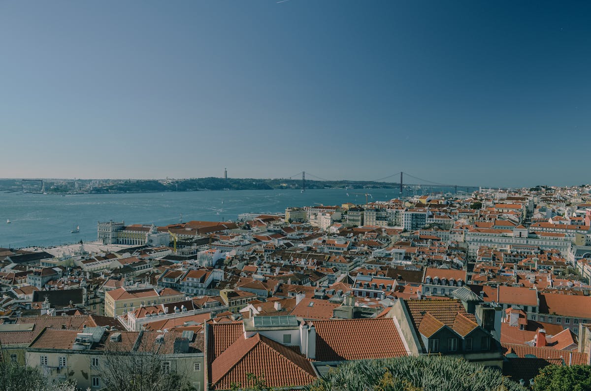 Panoramic view of Lisbon red rooftops with the Tagus River and 25 de Abril Bridge in the background