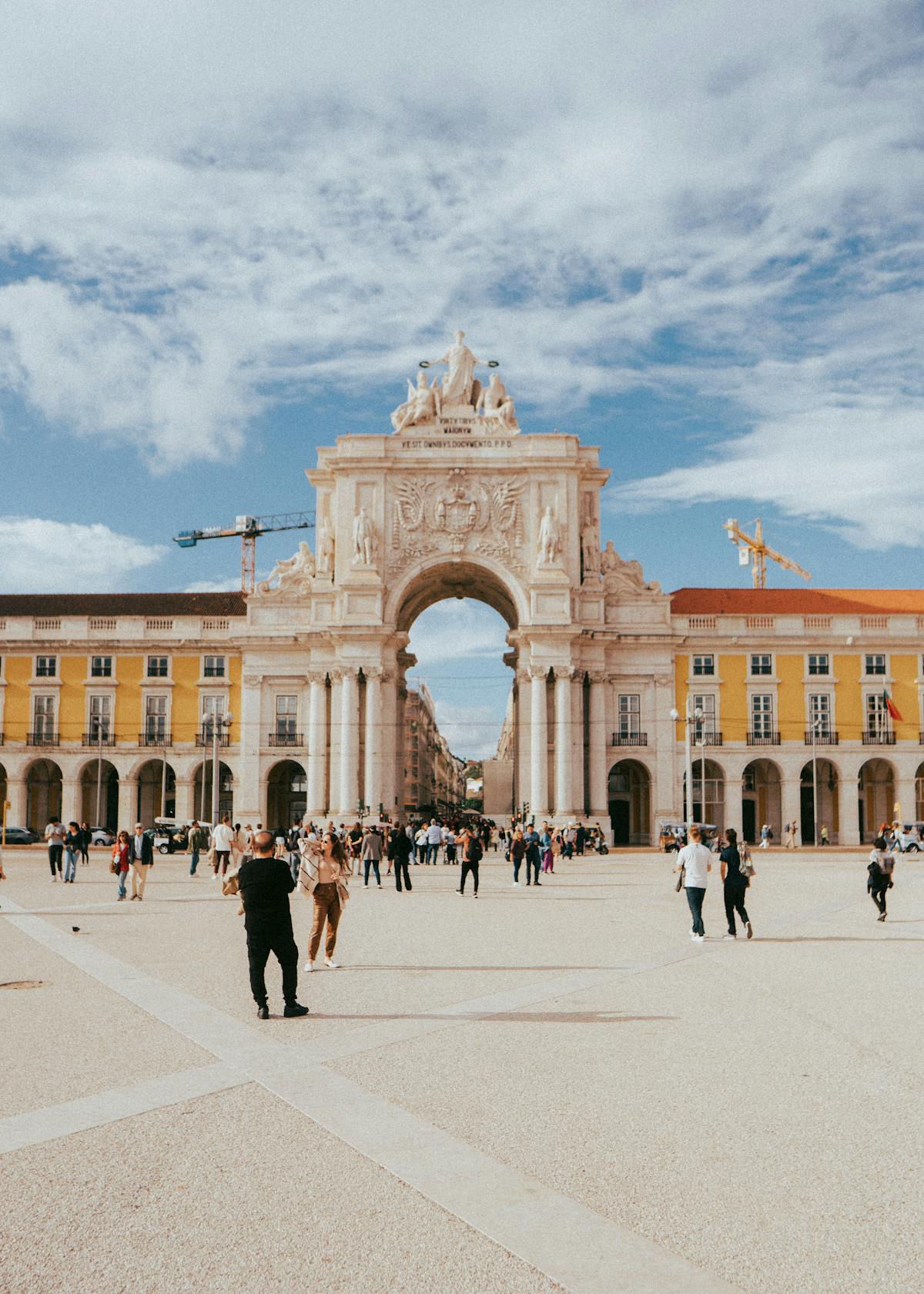 The Rua Augusta Arch in Lisbon with travelers on a sunny day