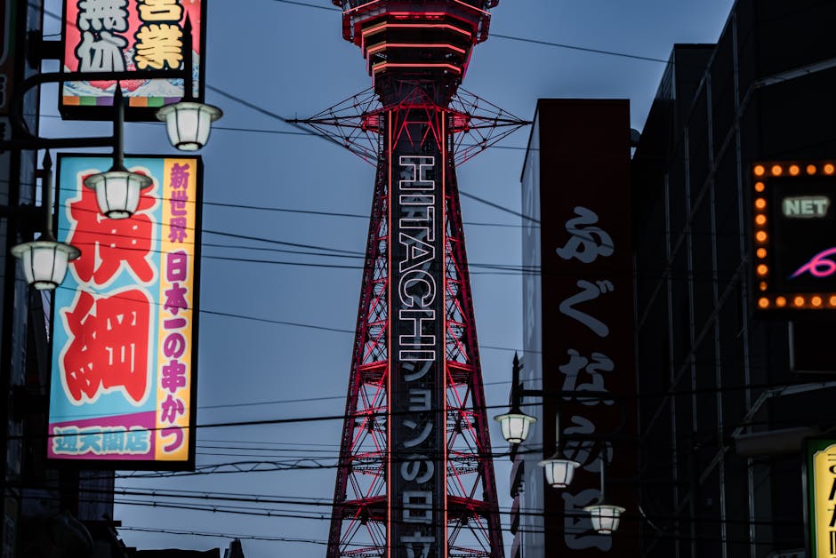Vibrant neon signs and Tsūtenkaku Tower illuminated at night