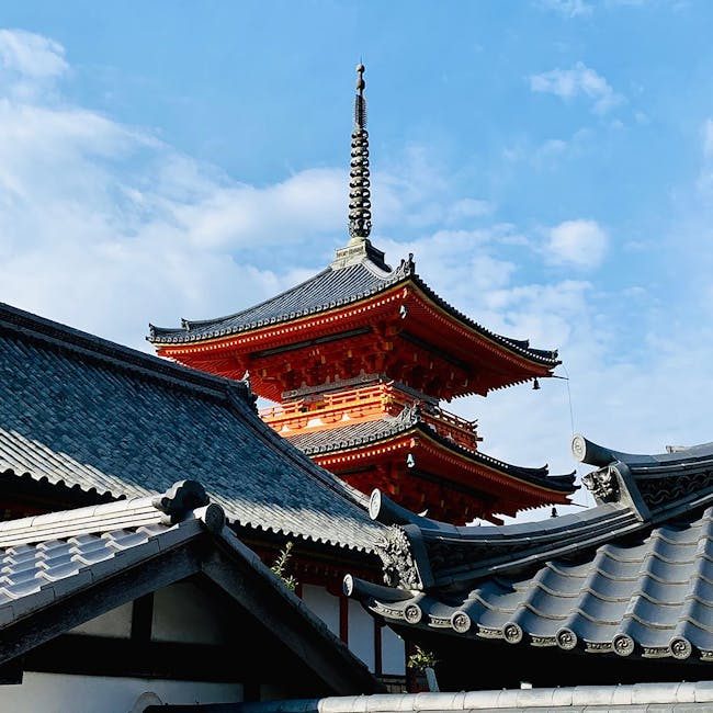From below of ancient ornamental pagoda in Kiyomizu dera temple complex located in Kyoto against blue sky on sunny day
