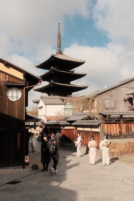 A serene scene capturing the iconic Yasaka Pagoda in Kyoto with visitors in traditional attire.