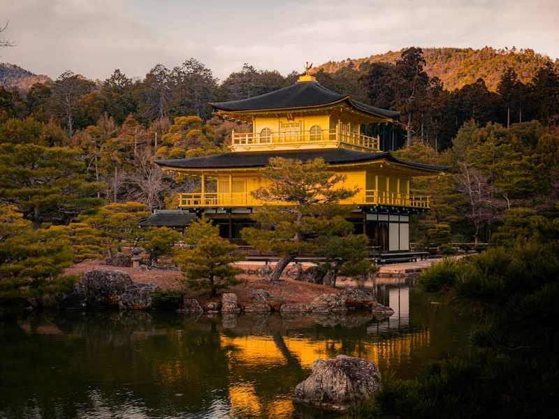 Kinkaku-ji Temple at sunset, reflecting on a serene pond in Kyoto, Japan.