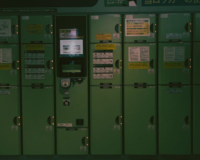 A row of green lockers in a Kyoto subway station, highlighting urban convenience.