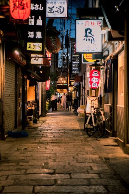 Explore a bustling Osaka alley at night, illuminated by traditional lanterns and lively signage.