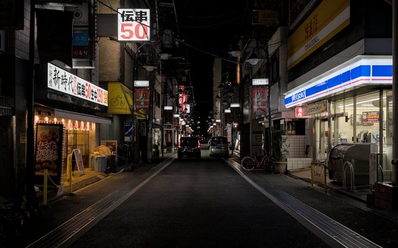 Explore the lively nightlife of Takatsuki, Japan in this urban scene featuring stores and vibrant lights.