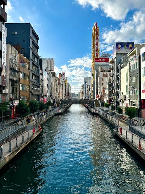 Explore the lively Dotonbori Canal in Osaka, Japan on a bright day, showcasing its urban charm.
