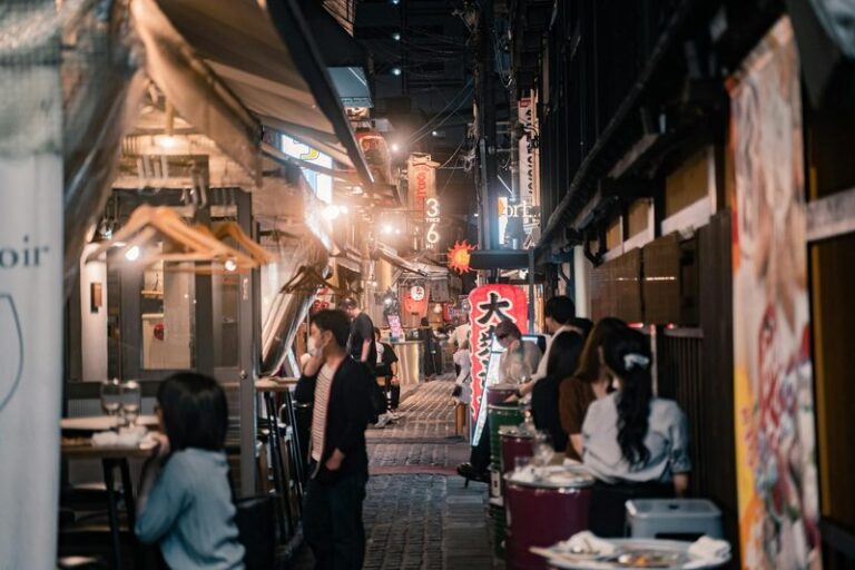 Bustling Osaka alleyway lined with inviting eateries and street food stalls