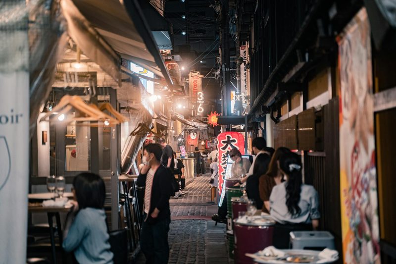 Bustling Osaka alleyway lined with inviting eateries and street food stalls