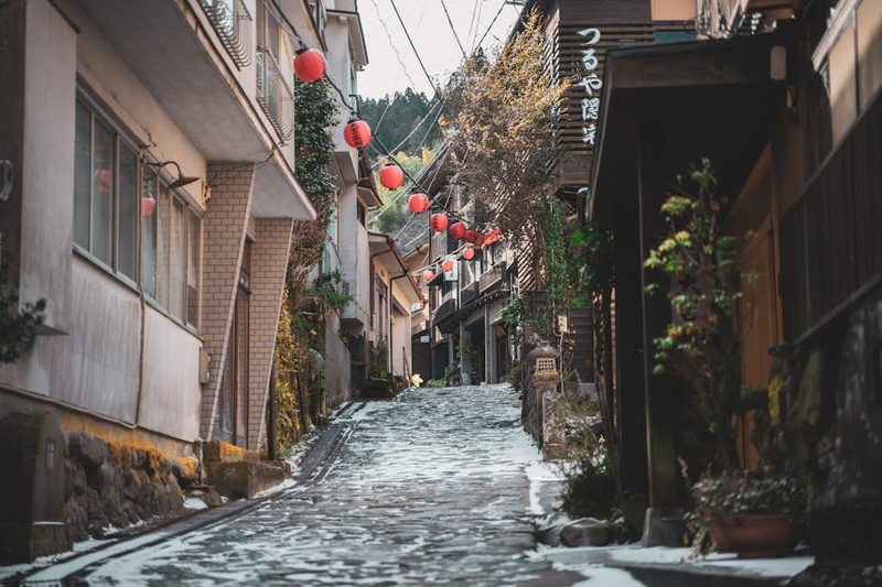Captivating view of a snowy street adorned with red lanterns in Osaka, Japan, capturing traditional architecture and cultural ambiance.