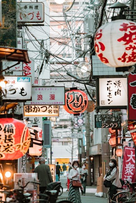 Explore the lively streets of Osaka filled with vibrant signs and bustling market activity, capturing the urban vibe.