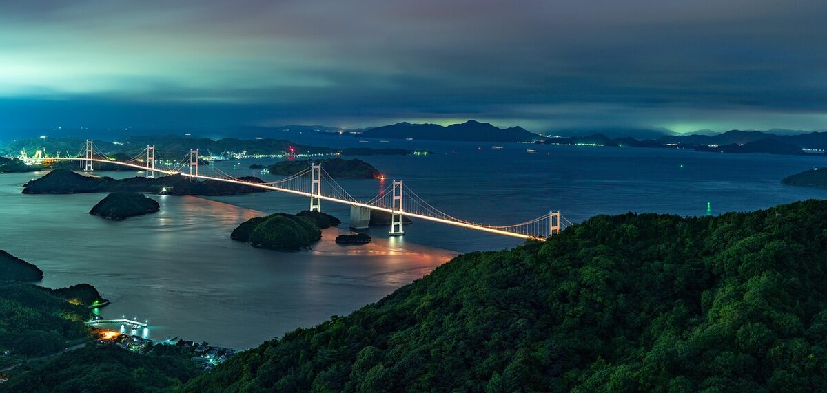 Shimanami Kaido highway and bridge lit up at night across the Seto Inland Sea archipelago, Ehime Prefecture