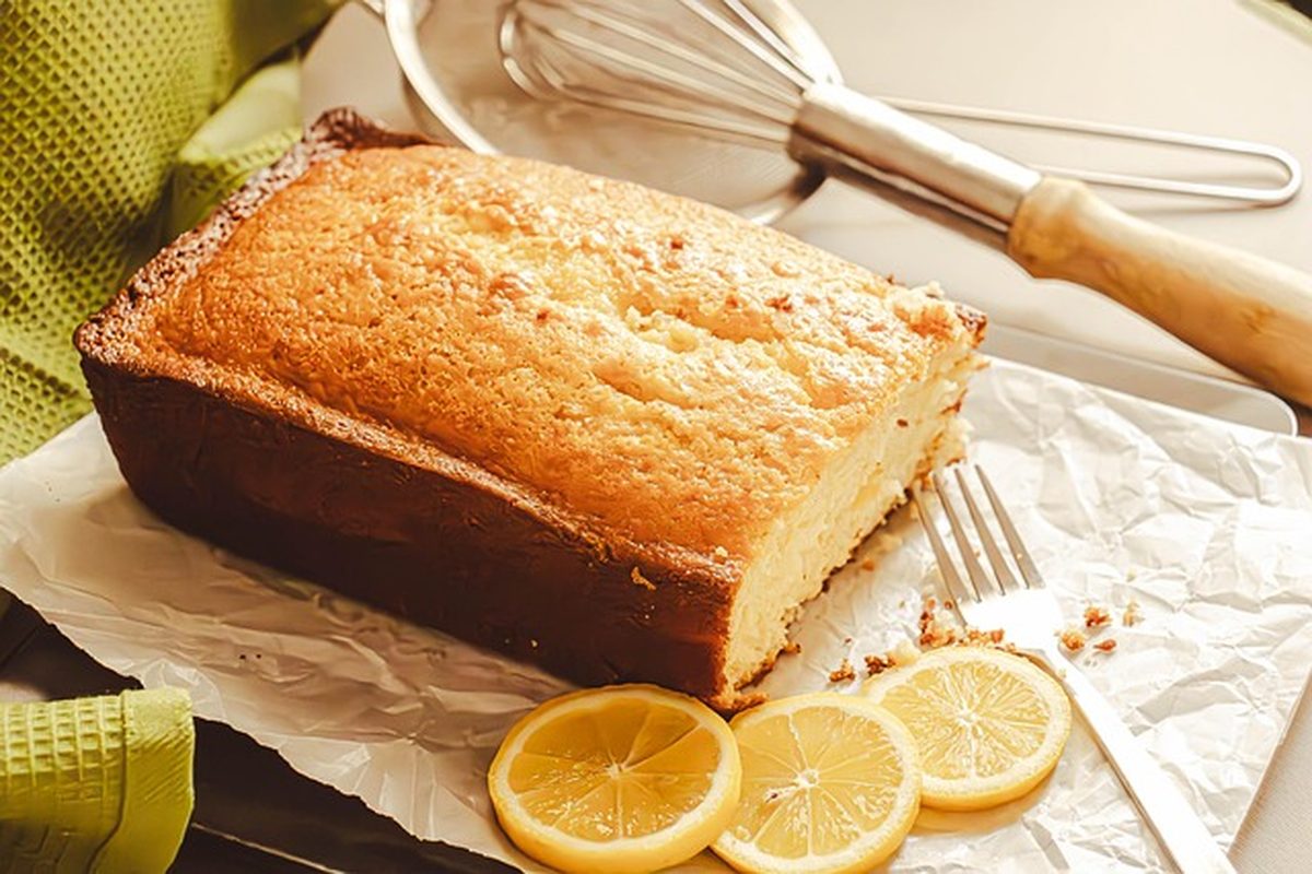 Freshly baked lemon cake dusted with sugar and garnished with lemon slices similar to the famous Setoda lemon cake