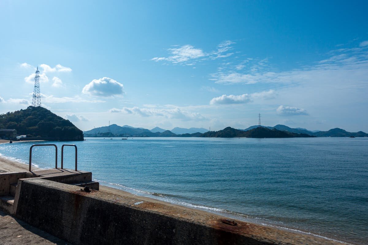 Stone seaside embankment along the Onomichi waterfront with the Seto Inland Sea and distant islands