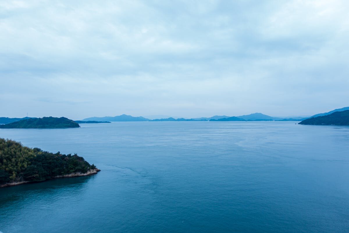 Calm seascape of the Seto Inland Sea with scattered islands and a soft golden light at Onomichi, Hiroshima