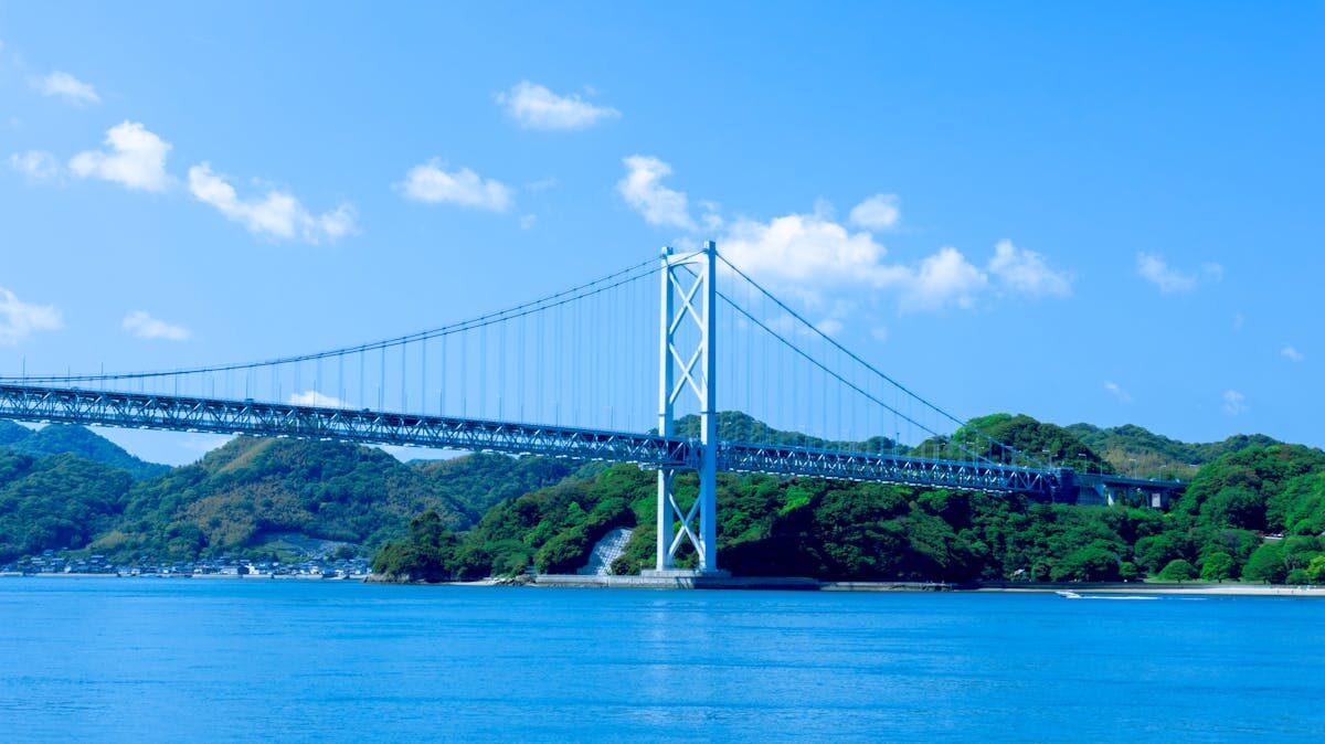 Long suspension bridge stretching across the Seto Inland Sea with islands visible in the distance