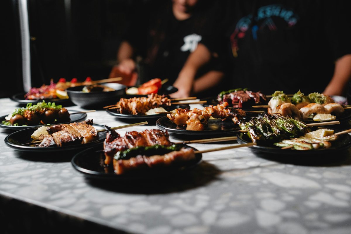 Assorted yakitori grilled chicken skewers displayed on dark plates, a popular post-ride meal in Imabari