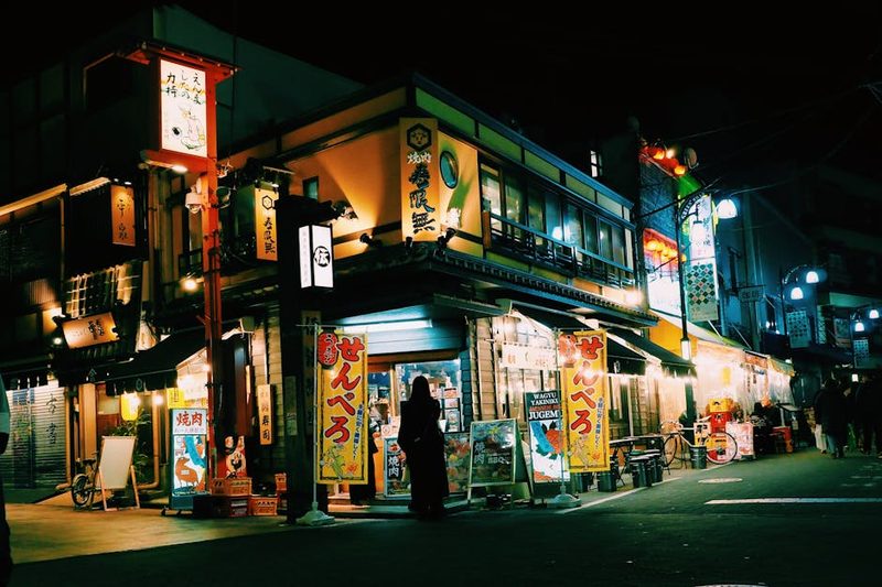 Vibrant Tokyo street at night showcasing traditional shops and glowing neon signs.