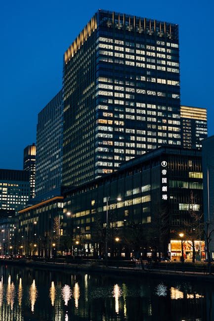 Illuminated skyscrapers reflecting on the canal in Chuo City, Tokyo at night.