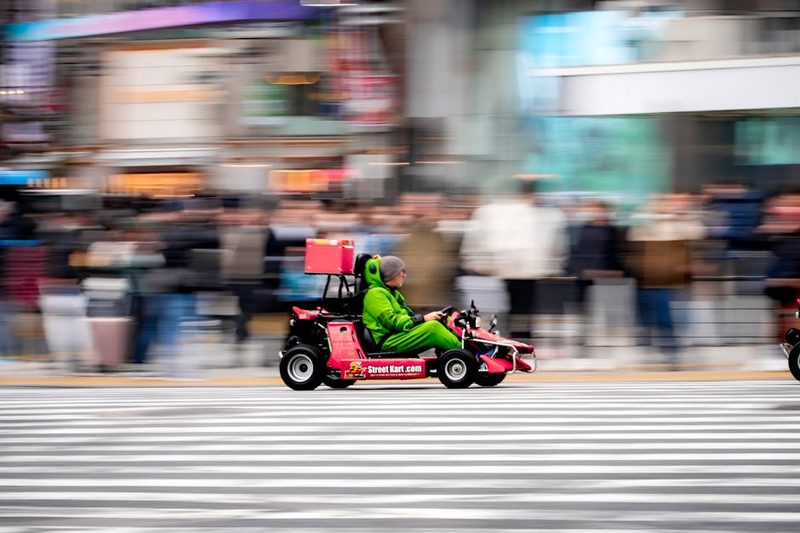 Colorful go-kart racing across the iconic Shibuya Crossing in Tokyo, Japan during daytime.