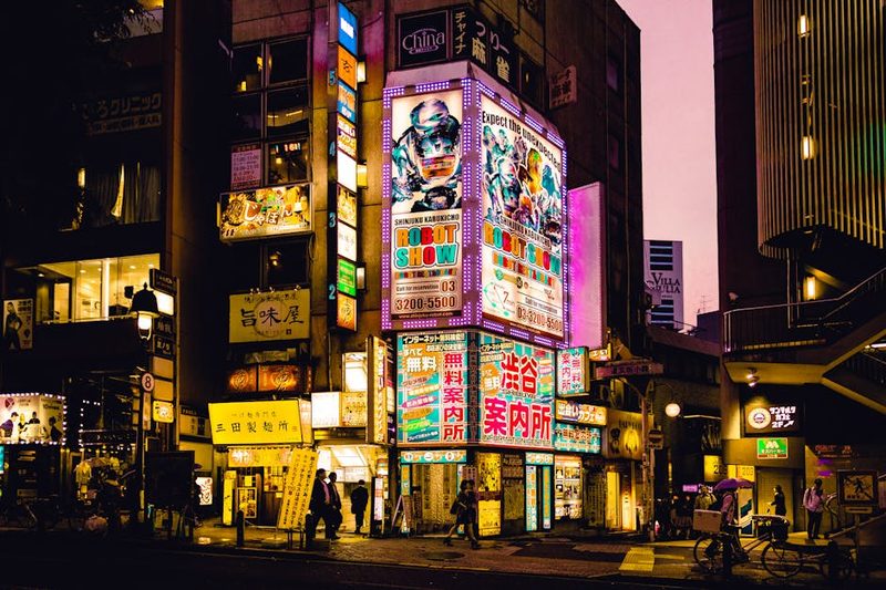 Explore the vibrant nightlife of Shinjuku, Tokyo with colorful neon signs illuminating the bustling streets.