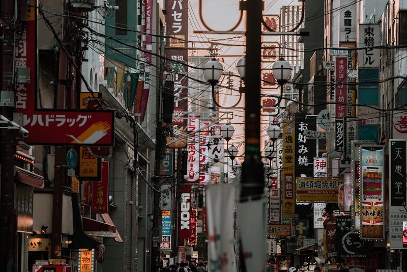 Bustling Tokyo street filled with colorful neon signs and urban architecture, capturing the city's lively essence.