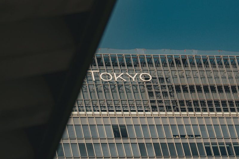 A view of a modern building in Tokyo with reflective glass and urban architecture.