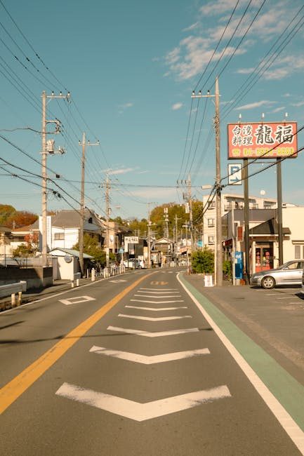 A tranquil urban street in Tokyo, Japan, under a clear blue sky, capturing local buildings and signage.