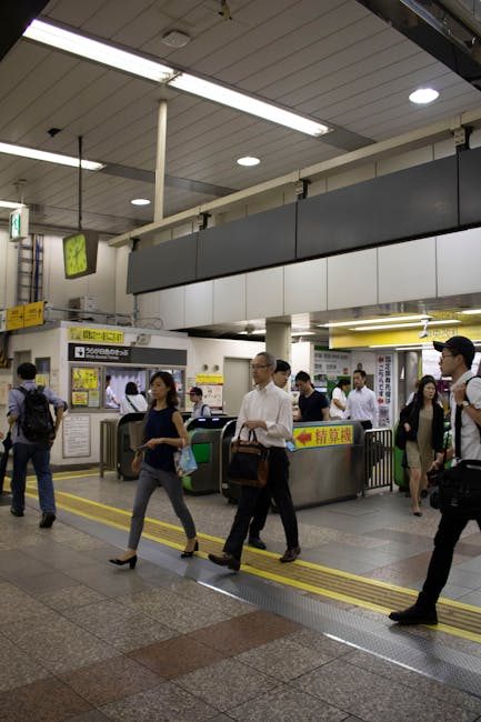 People walking in a Tokyo subway station, busy urban commuting scene.