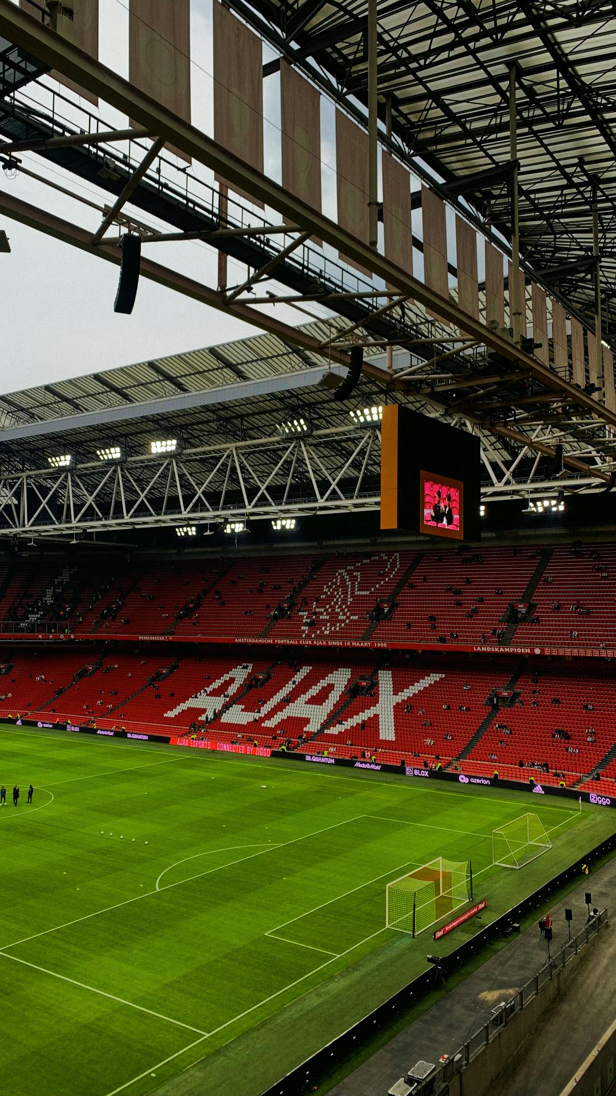 Inside the Johan Cruyff Arena in Amsterdam showing the iconic red stadium seats and green pitch