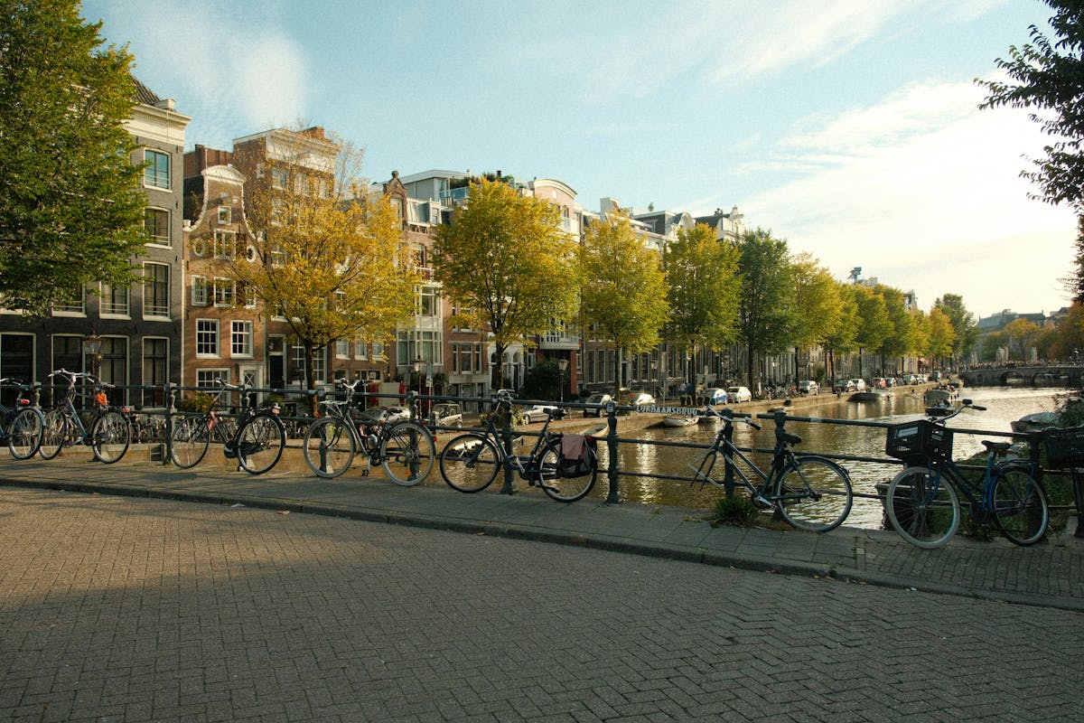 Scenic Amsterdam canal lined with bicycles and autumn trees