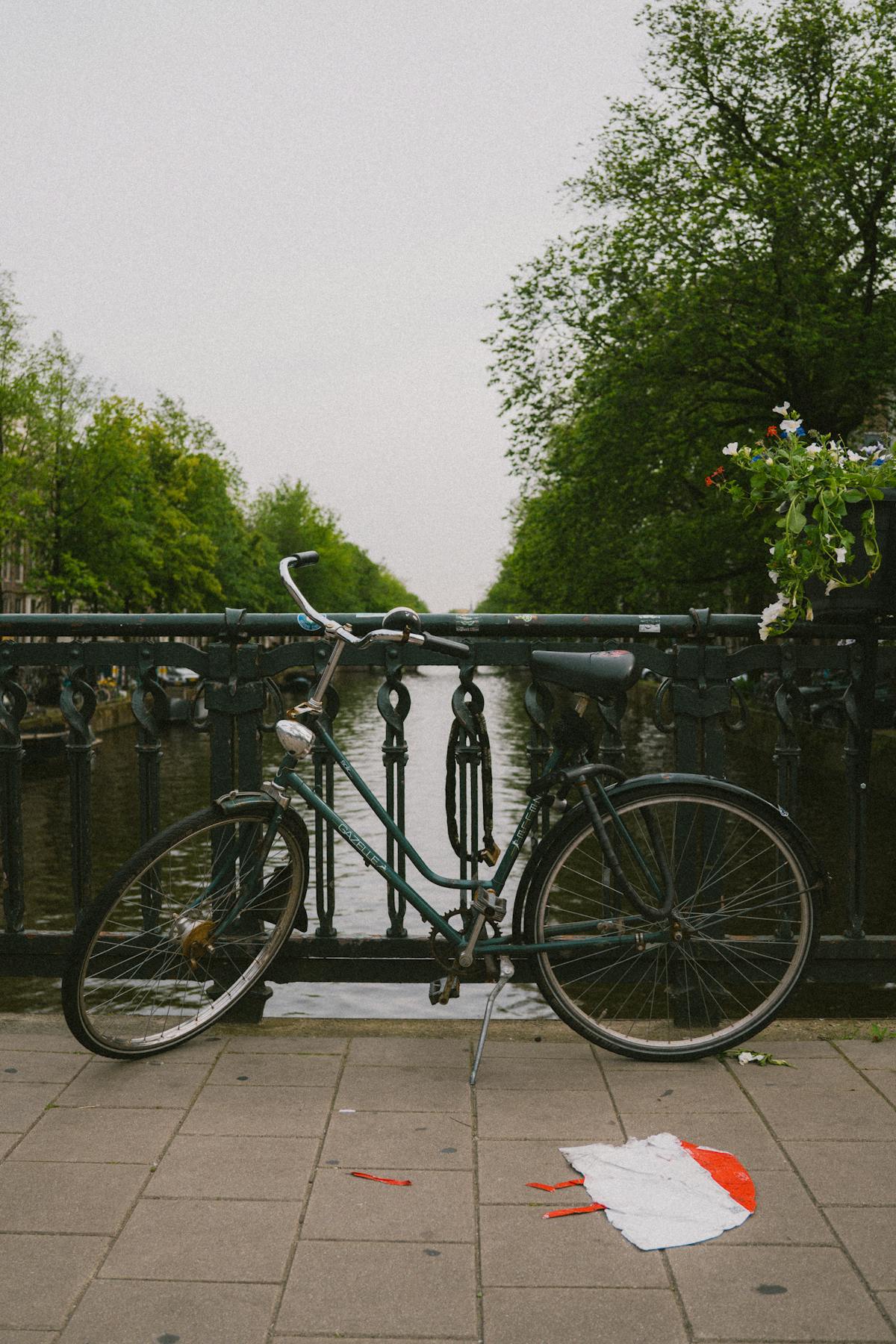 Bicycle parked on an Amsterdam canal bridge in spring