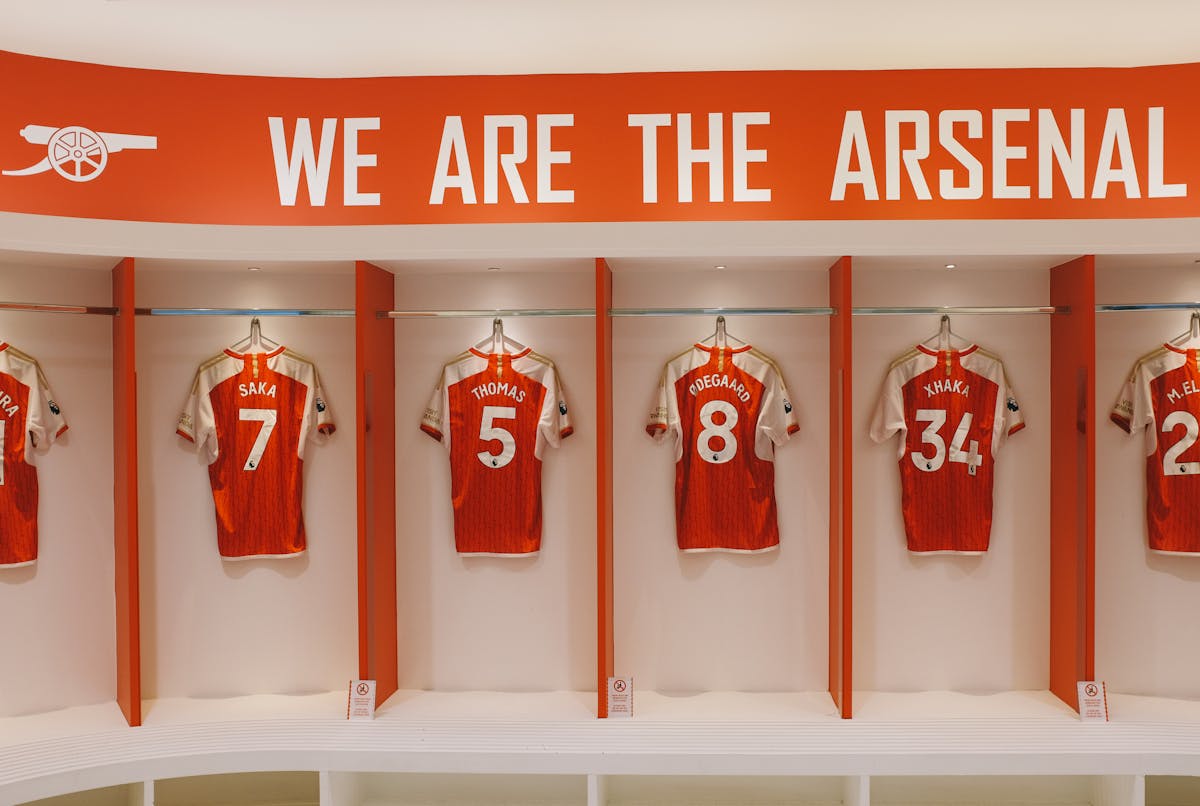 Football jerseys hanging in a stadium dressing room during a tour