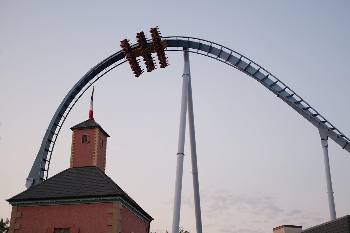Dramatic image of a roller coaster ascending high with scenic sunset backdrop