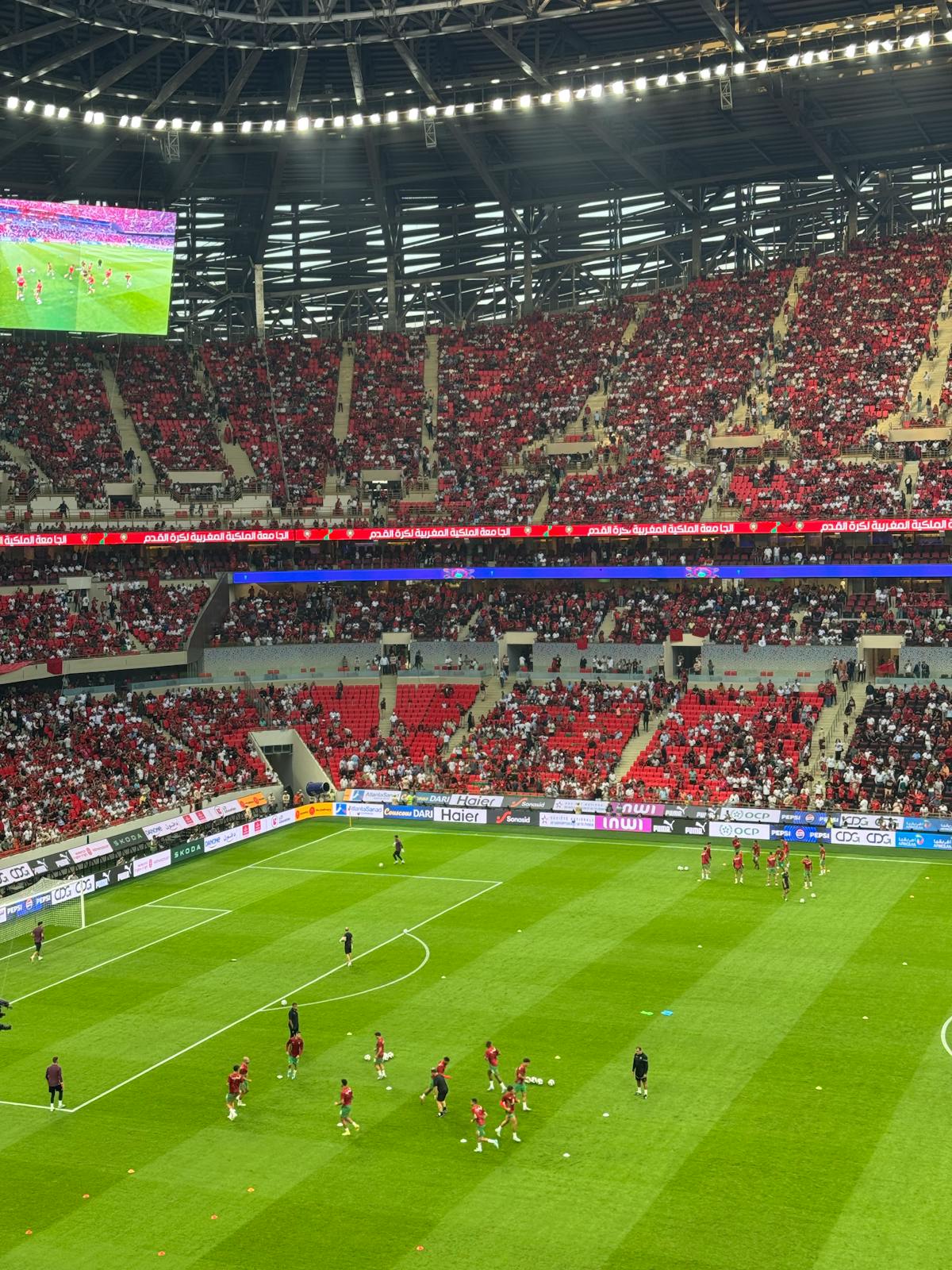 Packed football stadium with fans during a match under stadium lights