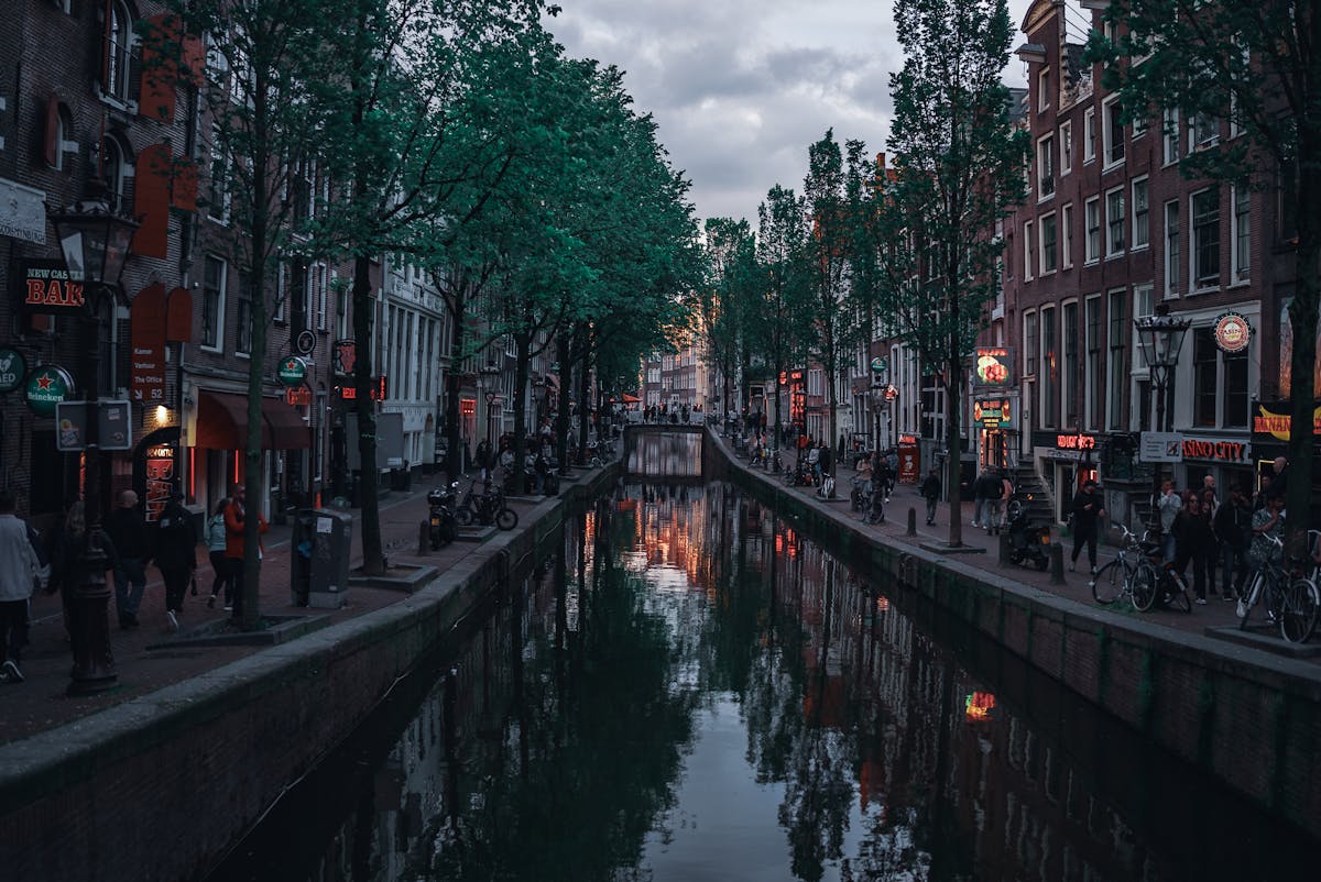 Evening scene at Amsterdam canal with lit buildings during twilight
