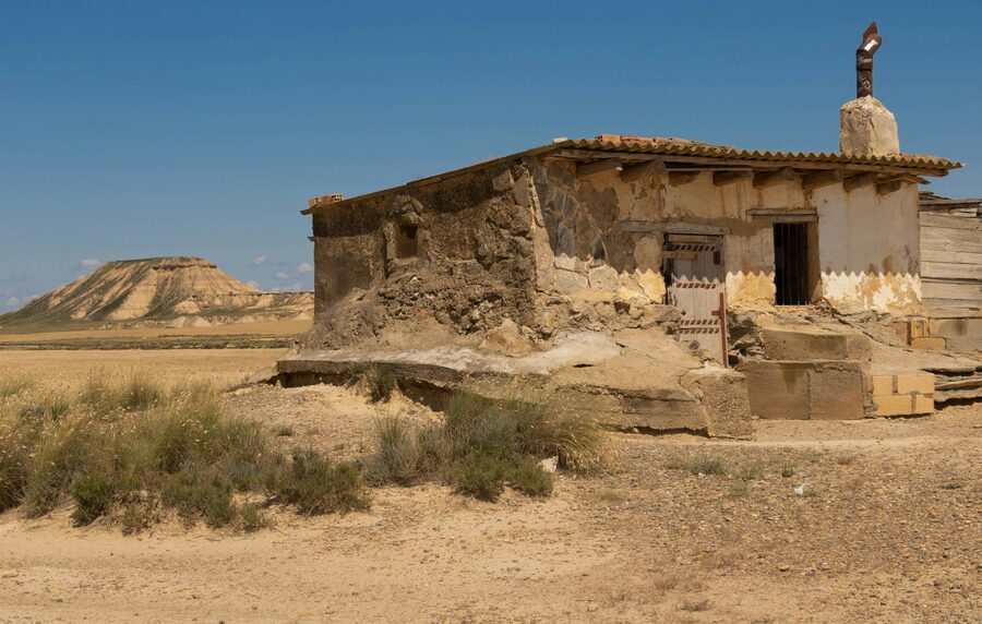 Abandoned stone house in the Spanish desert under bright blue sky