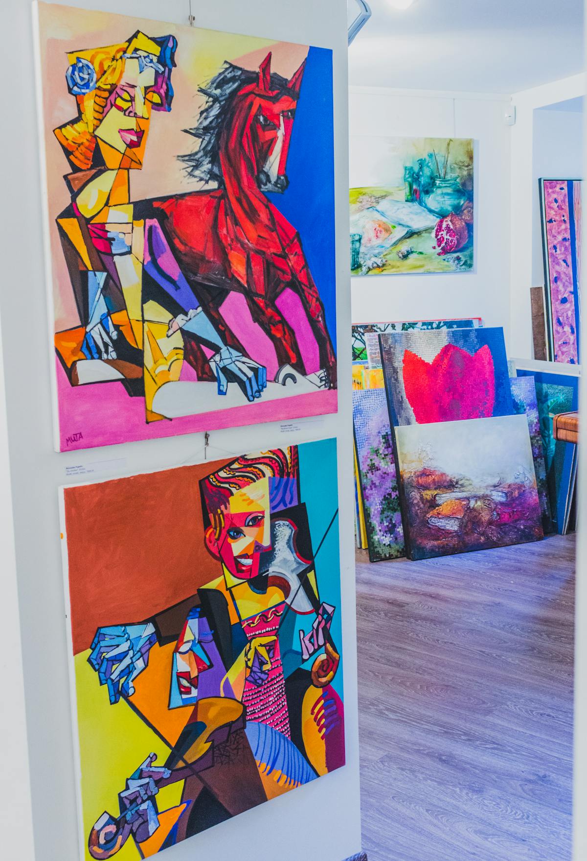 Colorful abstract artworks displayed in a well-lit art gallery