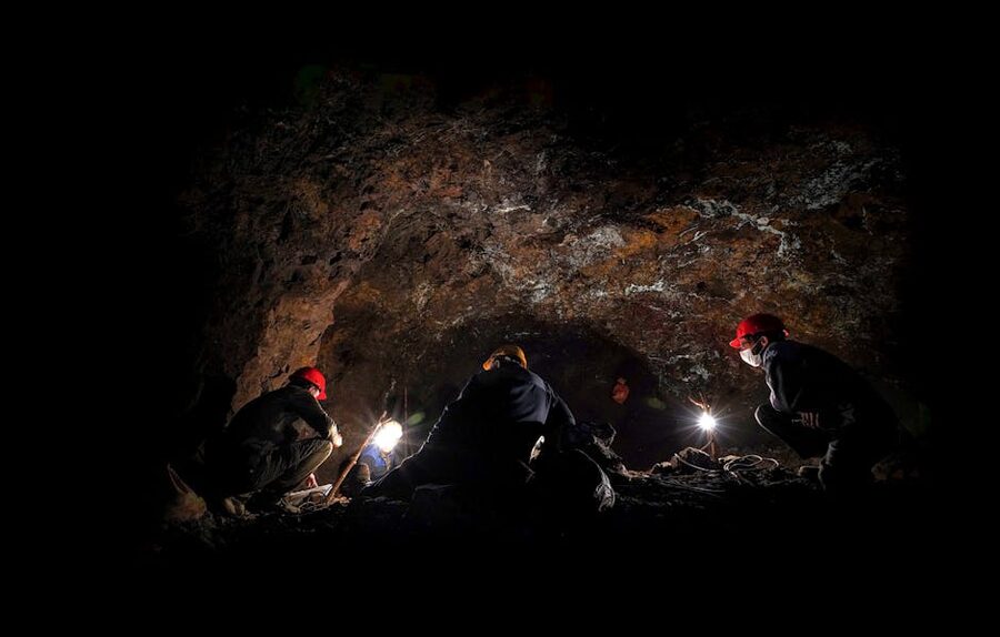 Cavers wearing helmets at cave entrance