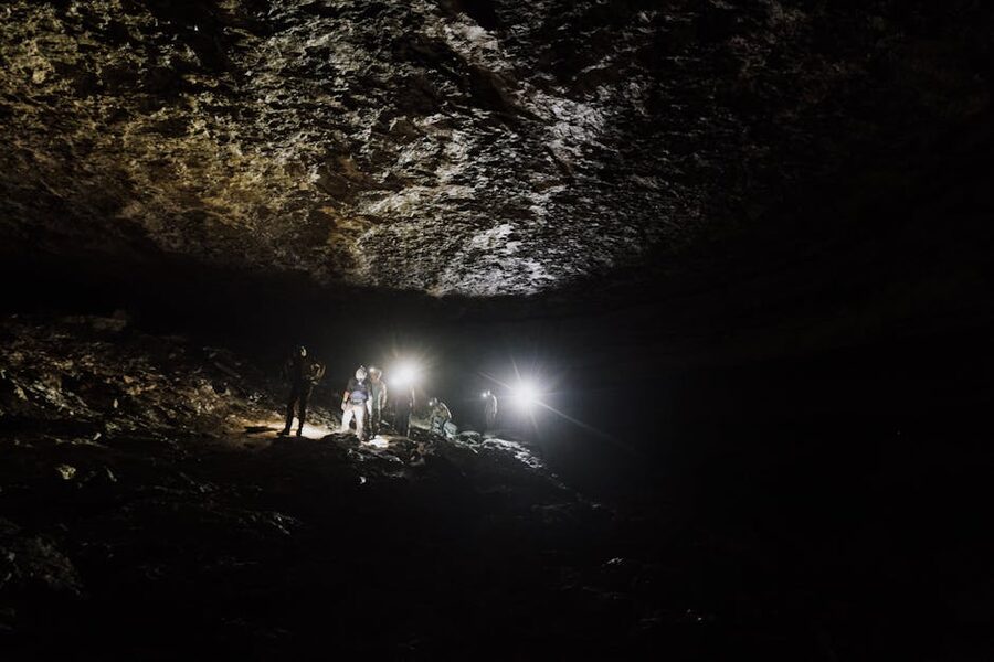 Group of cavers with headlamps in dark passage