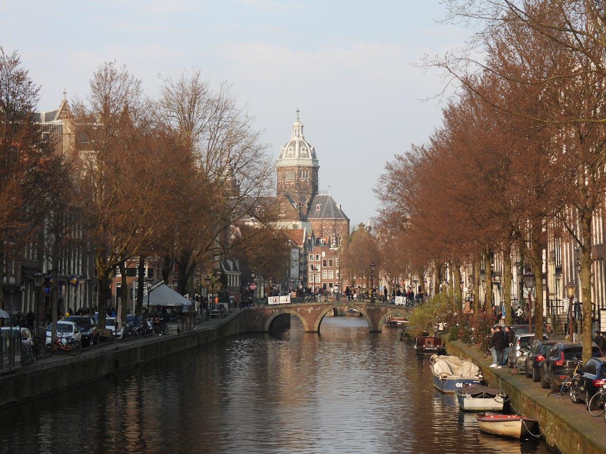 Amsterdam canal with historic buildings and a stone bridge in autumn