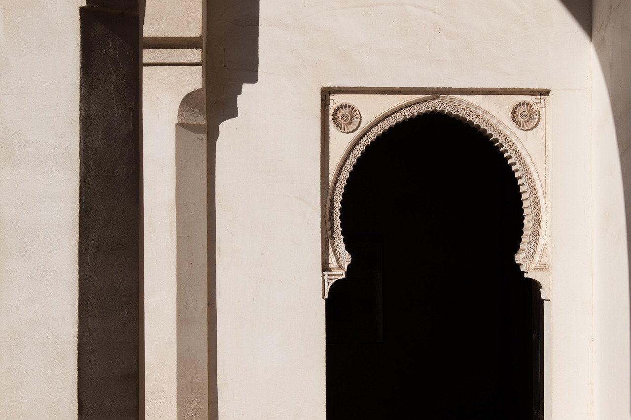 Sunlight streaming through ancient Moorish arches inside the Alcazaba of Malaga with views of gardens beyond