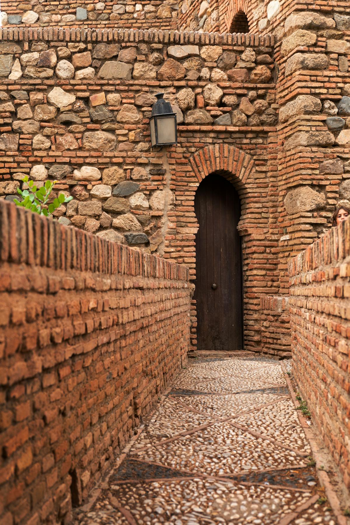 Detailed stone and brick archway inside the Alcazaba fortress in Malaga showing Moorish architectural details