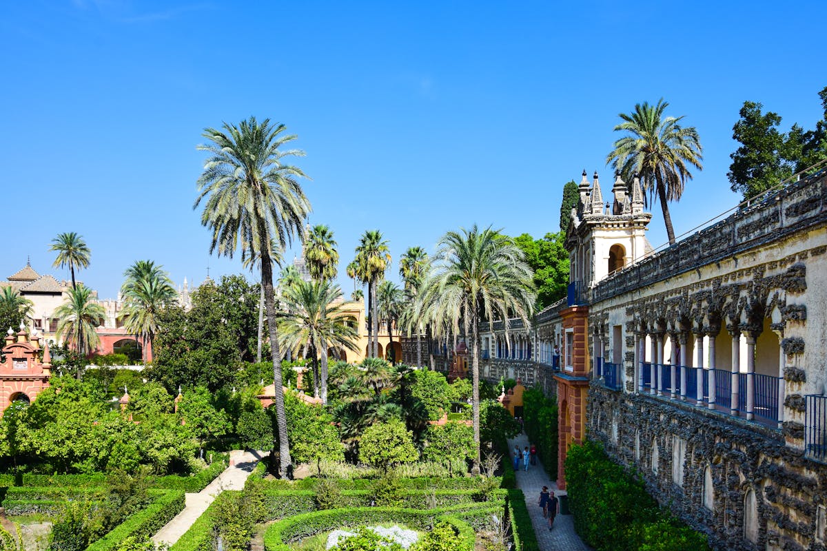 Royal Alcazar of Seville gardens with arched walkways and green hedges