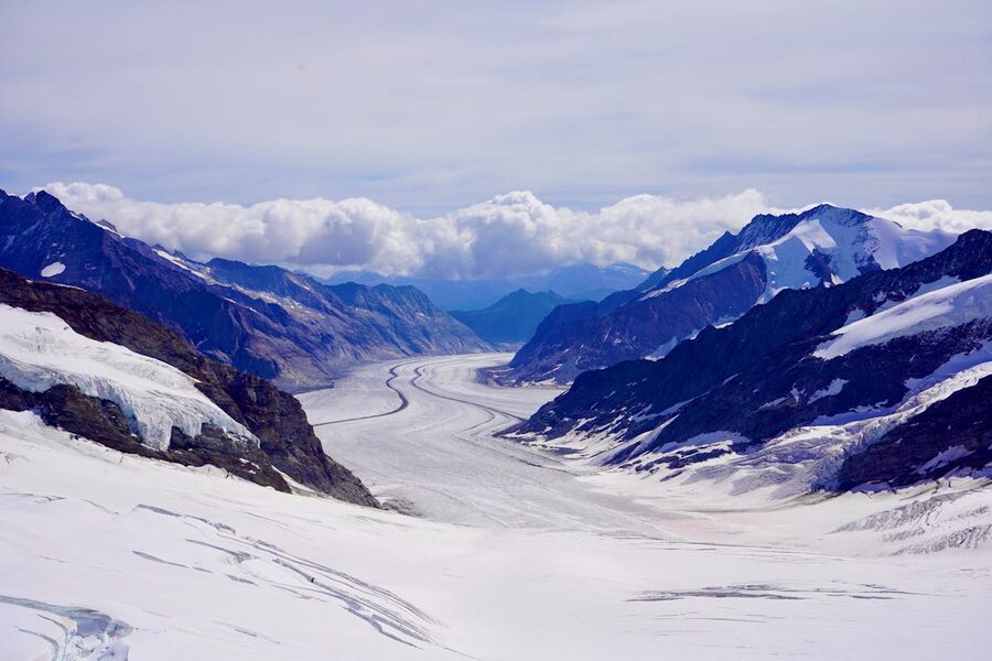 Aerial view of the Aletsch Glacier flowing between mountain ridges in the Swiss Alps