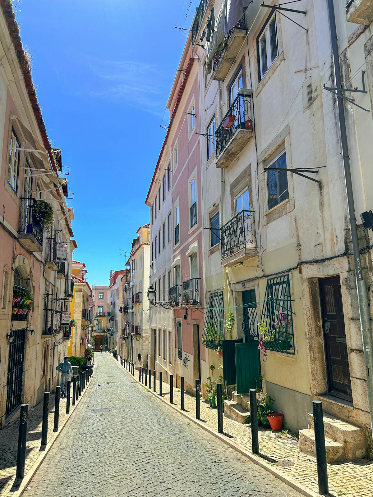 Narrow cobblestone alley in Lisbon Alfama district with traditional architecture