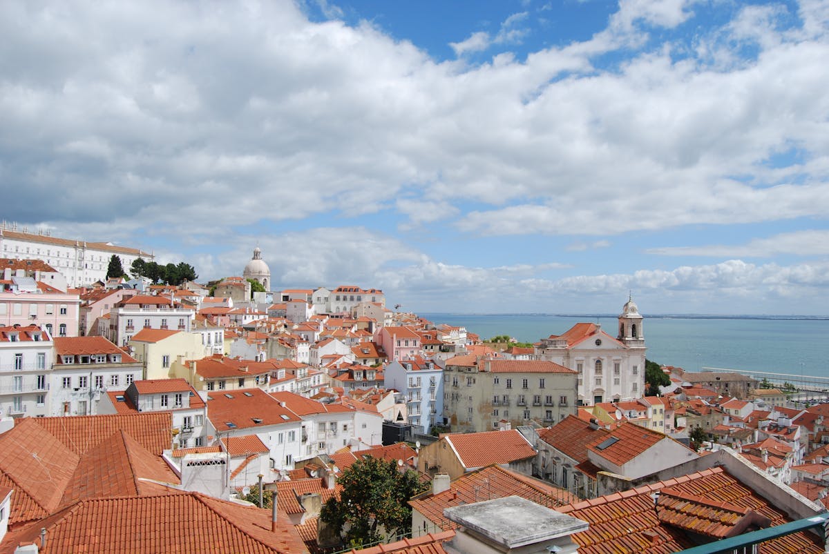 Panoramic view of Alfama district showing red terracotta rooftops stretching toward the Tagus River