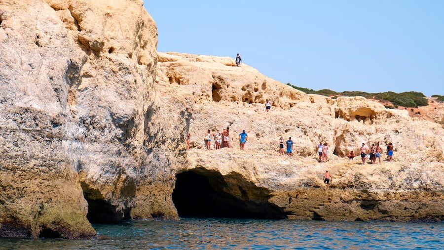 Tourists exploring the cliffs and caves along the Algarve coast
