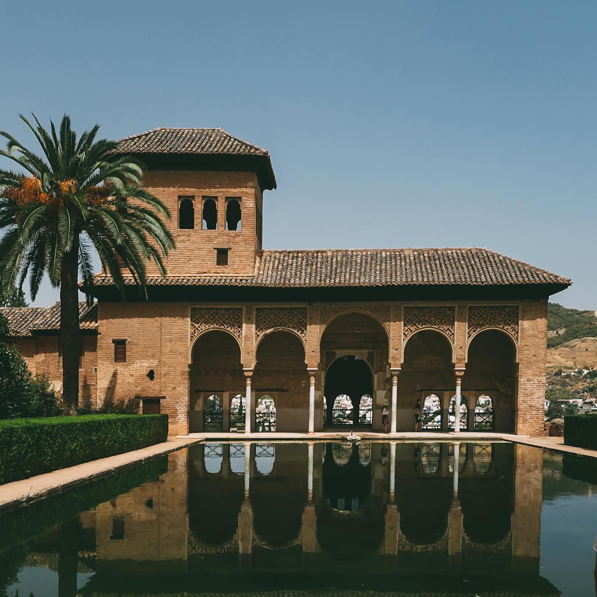 The Alhambra's arches and their reflection in a courtyard pool